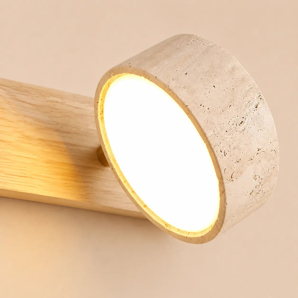 Close-up of the Oren travertine wall light stone shade with warm diffused illumination