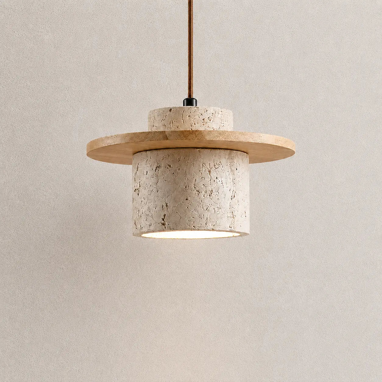 Aro stone pendant light with a textured stone shade, natural wood accent, and warm downward glow