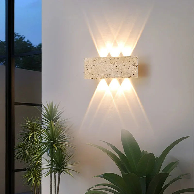 Aure stone wall light adding warm decorative glow near an outdoor entryway