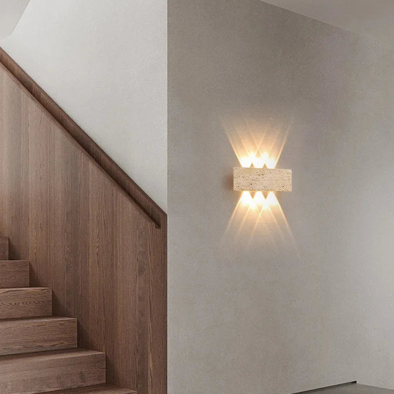 Aure stone wall light creating a soft warm accent on a stairway wall