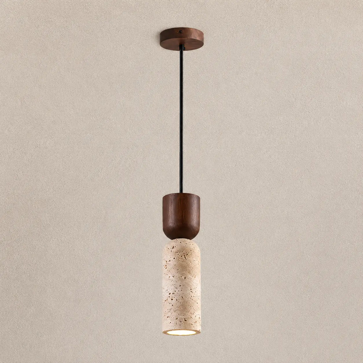 Auren stone pendant light with a slim textured stone shade, dark wood accent, and warm downward glow