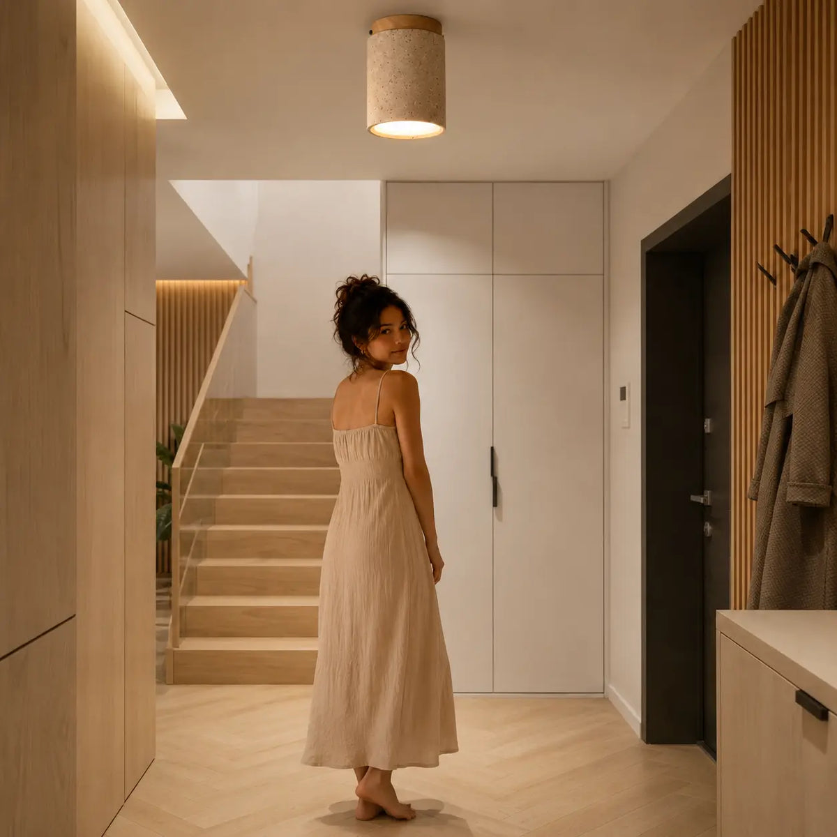 Aven stone ceiling light adding a quiet warm glow to a modern hallway interior