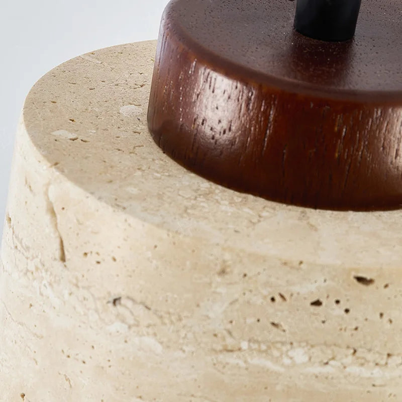 Close-up of the Ciela stone pendant light with dark wood top detail and textured stone shade