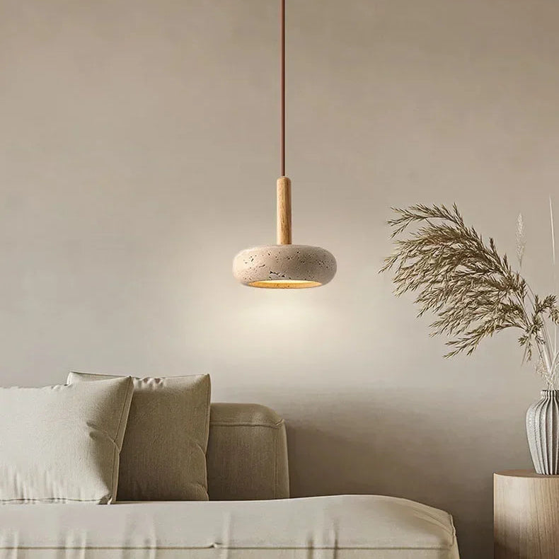 Lume stone pendant light adding soft warm light beside a neutral living room sofa