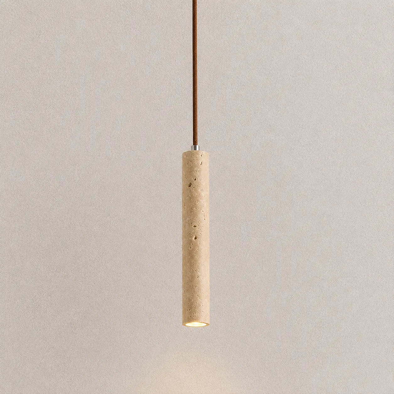 Neri travertine pendant light with a slim vertical stone shade and warm downward glow