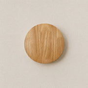 Orvane wooden wall light with a round wood-finish shade and soft warm backlit glow
