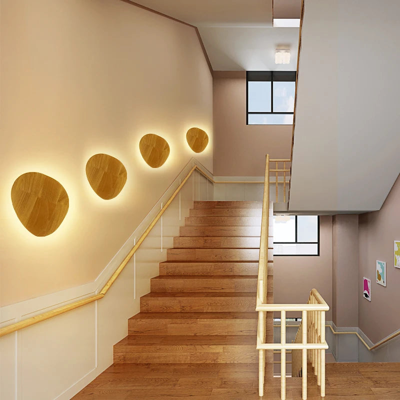 Orvane wooden wall lights adding warm decorative illumination along a stairway wall