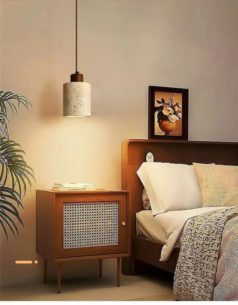 Selo stone pendant light creating a soft warm glow beside a neatly styled bed
