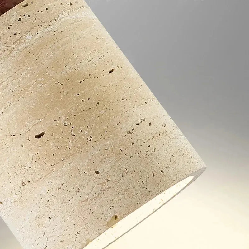 Close-up of the Selo pendant light with dark wood top detail and textured stone shade