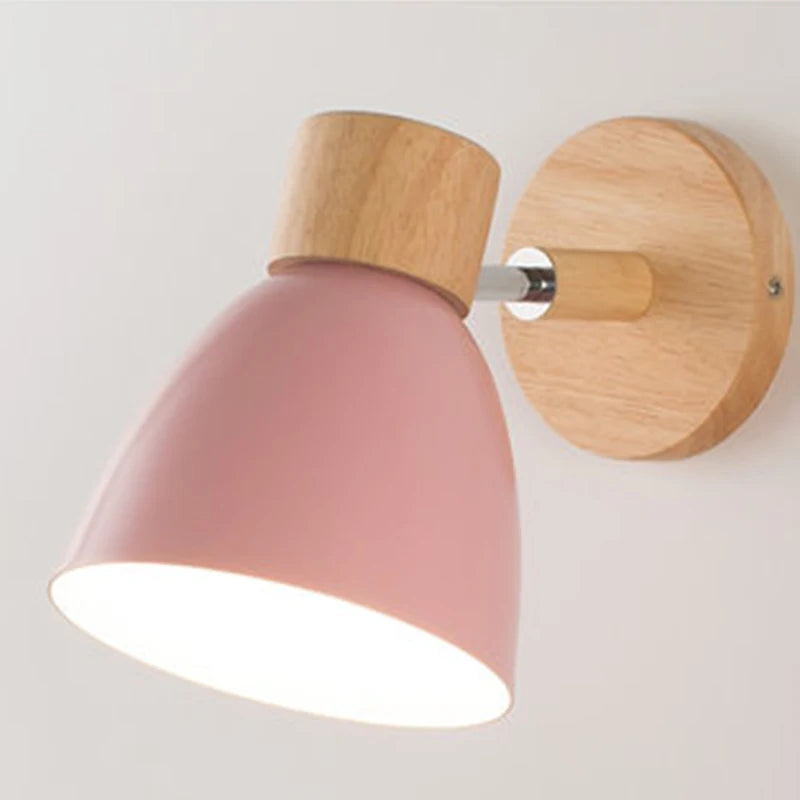 Solenne macaron wall sconce in pink with a natural wood mount and warm downward glow