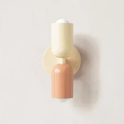 Solvi macaron wall light in cream and peach tones with a soft rounded shade and warm downward light