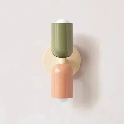 Solvi macaron wall light in green and peach tones with a soft glowing shade and wall-mounted design