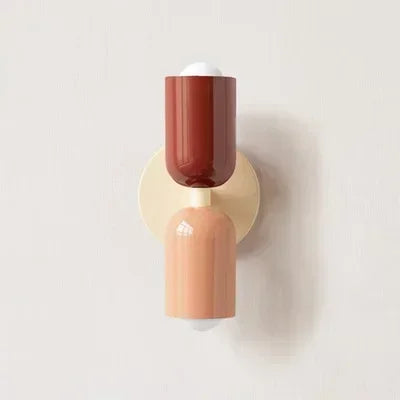 Solvi macaron wall light in red and peach tones with a playful rounded silhouette and warm glow