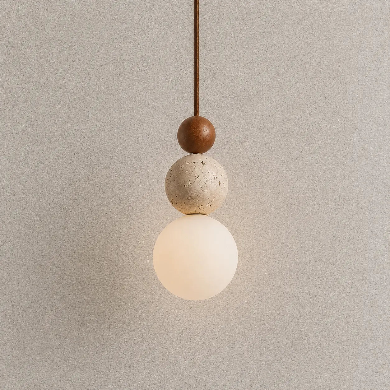 Veyra stone pendant light with layered wood and stone accents and a warm glowing globe shade