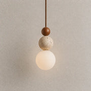 Veyra stone pendant light with layered wood and stone accents and a warm glowing globe shade