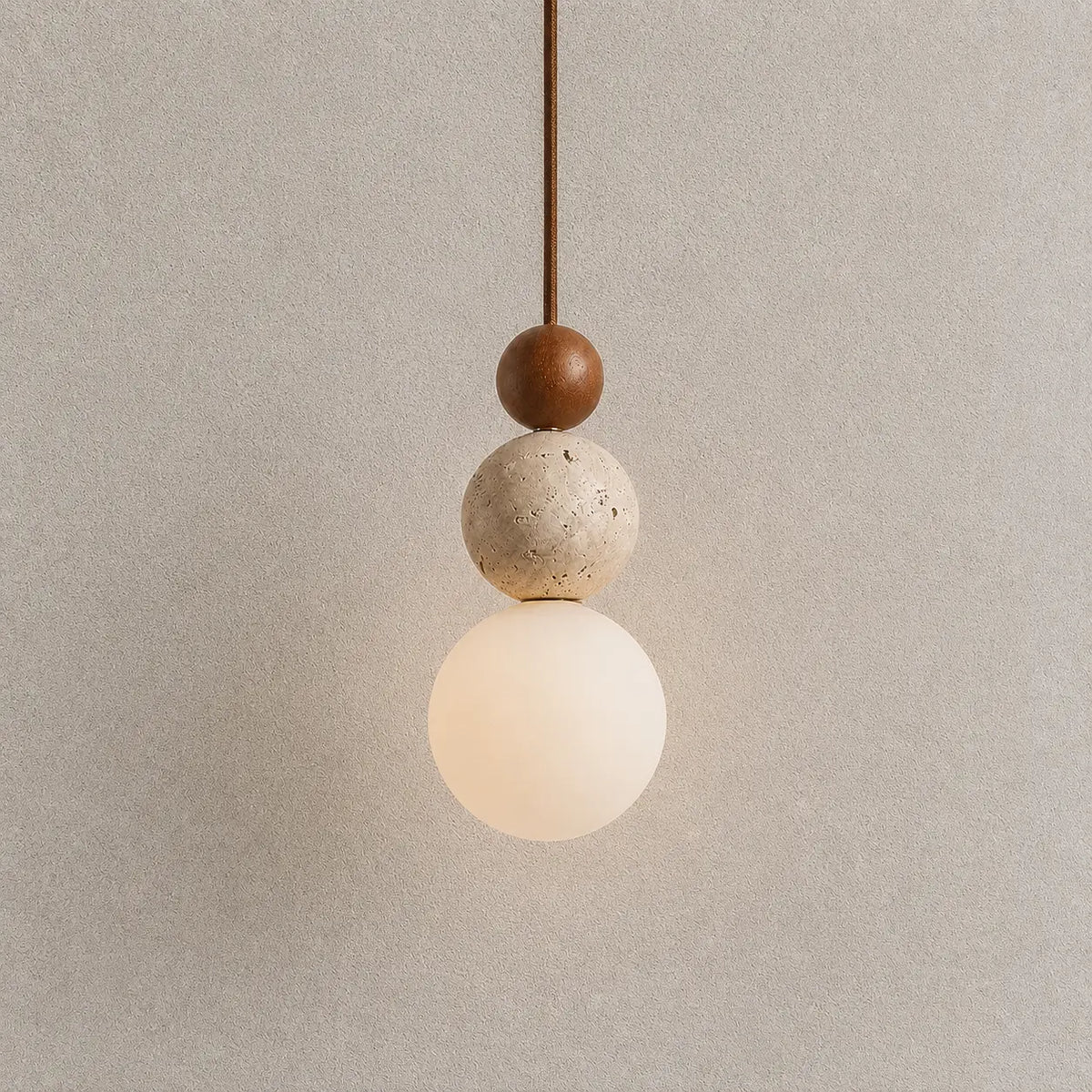 Veyra stone pendant light with layered wood and stone accents and a warm glowing globe shade