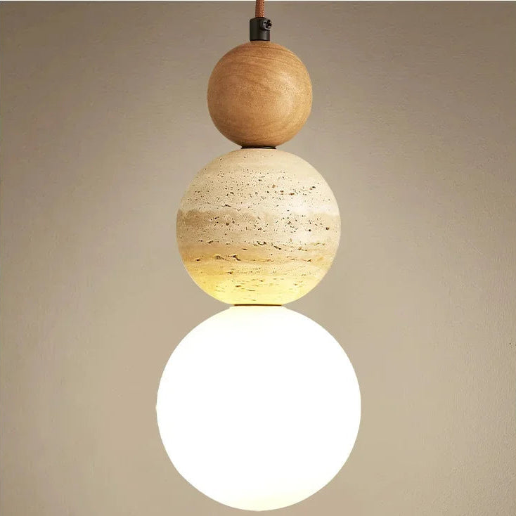 Close-up of the Veyra stone pendant light with natural wood accent, stone detail, and warm globe shade