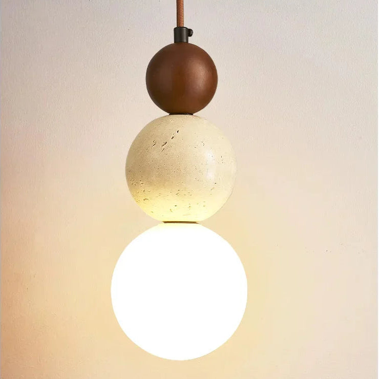 Close-up of the Veyra stone pendant light with walnut wood accent, stone detail, and warm globe shade